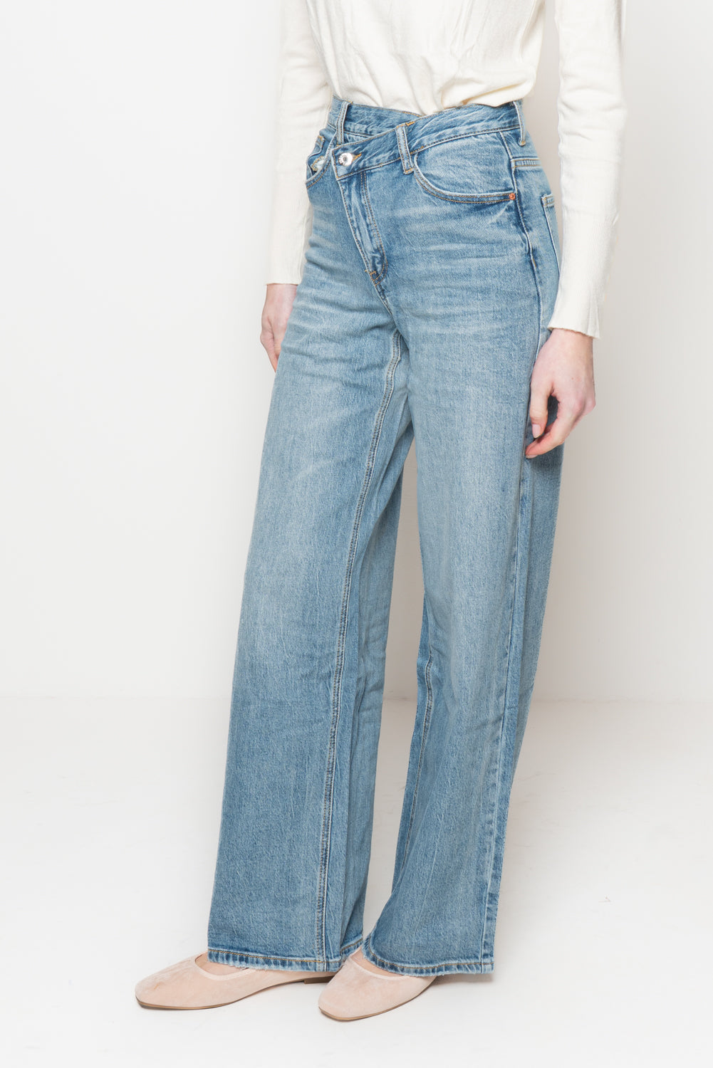 Jeans con bottone storto