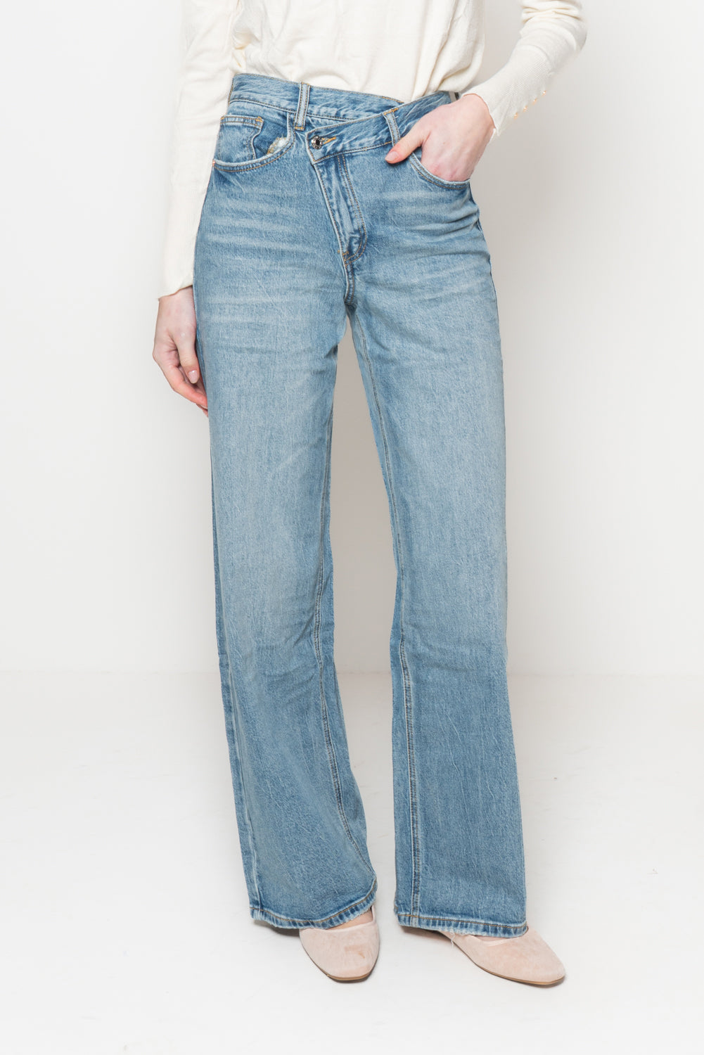 Jeans con bottone storto